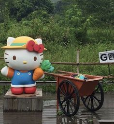 a hello kitty statue sitting on top of a wooden cart