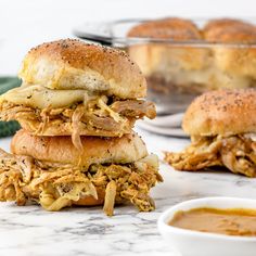 two sandwiches stacked on top of each other next to a bowl of soup and bread