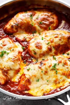 chicken parmesan in a skillet with red sauce and fresh herbs on top