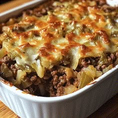 a casserole dish with meat and vegetables in it on a wooden table top