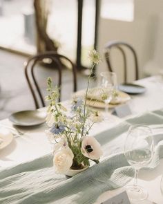 the table is set with white and blue flowers