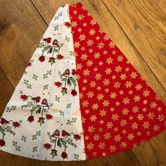 three pieces of fabric sitting on top of a wooden floor, one red and the other white