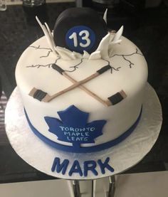 a hockey themed birthday cake with the number 13 on it and two sticks sticking out of it