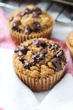 three chocolate chip muffins sitting on top of a towel