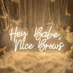 the words hey babe, nice brows are lit up in front of an image of flowers