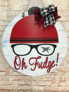 a wooden sign that says oh fudge with glasses and a bow on it's head