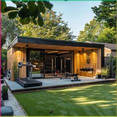 a home gym with exercise equipment in the back yard, surrounded by lush green grass