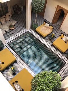 an aerial view of a living room with yellow furniture and potted plants on the floor