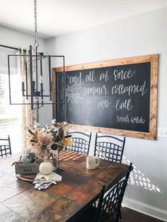 a dining room table and chairs with a chalkboard on the wall above it that says, and all at once, summer inspired mr call