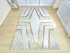 a white and gold area rug in the middle of a kitchen with appliances on the side