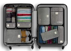 an open suitcase filled with lots of clothes and folded ones in it's compartments