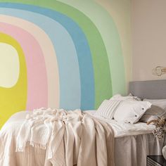 a bedroom with a rainbow painted on the wall