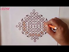 someone is drawing an intricate design on paper with colored pencils in their left hand