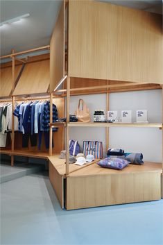 a clothing store with wooden shelves and clothes on hangers