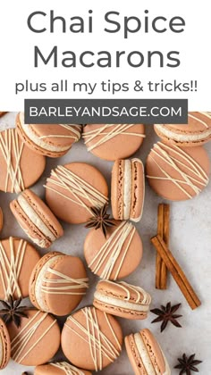 cinnamon spice macarons on a white surface with cinnamon sticks and star anise