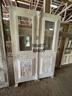 an old white double door with carvings on it