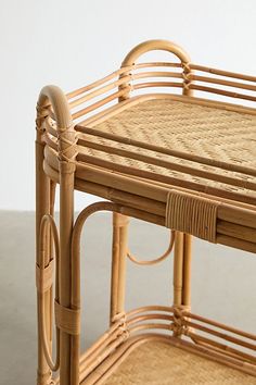 a wicker and rattan serving tray with handles on the bottom, sitting on top of a table