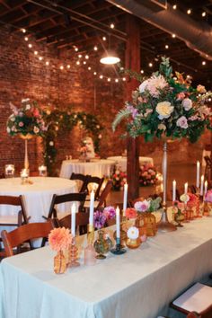 a long table is set with flowers and candles