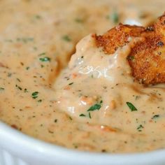 a white bowl filled with some kind of sauce and fried chicken on top of it