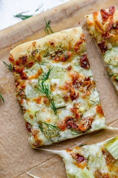 two slices of pizza sitting on top of a cutting board