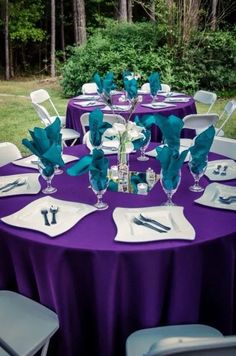 the table is set with purple and white linens