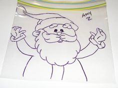 a drawing of a santa clause on a white surface with colored pencils in the background