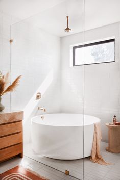 a white bath tub sitting in a bathroom next to a window