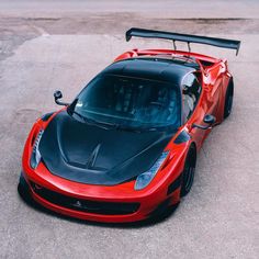 a red and black sports car parked in a parking lot