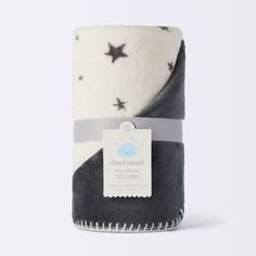 the blanket is black and white with grey stars on it, as well as a tag that says cloud island