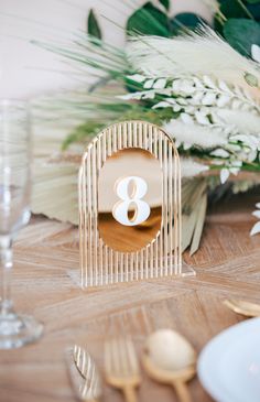 the table is set with white flowers and gold cutlery