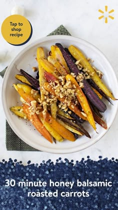 a white plate topped with carrots covered in nuts