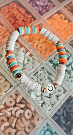 the beads are all different colors and sizes in this box, with a smiley face bead on it