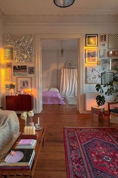 a living room filled with lots of furniture and pictures on the wall next to a doorway