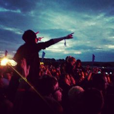 a man standing on top of a stage holding his arms out in front of an audience