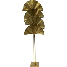 a tall metal sculpture with four leaves on it's sides and a wooden base