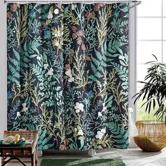 a bathroom with a shower curtain that has plants on it