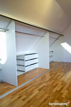 an empty room with wooden floors and white walls