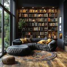 a living room filled with lots of books on top of a hard wood flooring