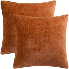 two brown velvet pillows sitting next to each other