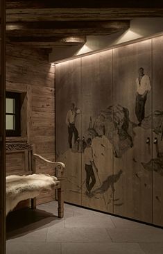 a room with wood paneled walls and paintings on the wall, along with a bench