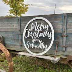 merry christmas from the schemps sign in front of a wooden wagon with wheels