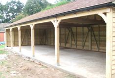 a large wooden building with two garages on each side and one attached to the roof