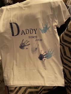 a t - shirt that says daddy since with hand prints on it