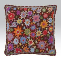 an embroidered pillow with multicolored flowers on the front and sides, made from wool