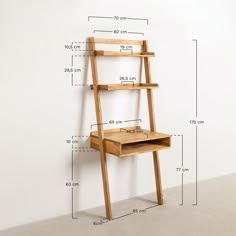 a wooden desk and shelf against a white wall with measurements for the top part of it