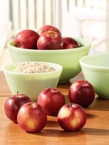 apples and oatmeal are sitting in bowls on a table