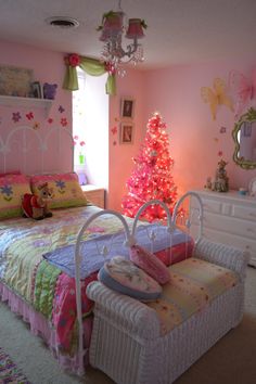 a bedroom decorated in pink and white with a christmas tree