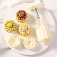 a white plate topped with different types of cookie cutters and pastry decorating tools