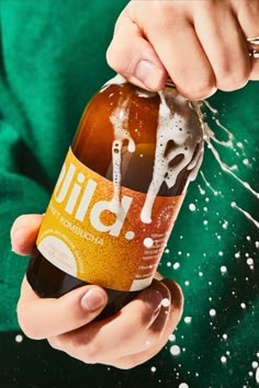 a person is holding a beer in their hand and sprinkled with white dots