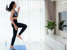 a woman is doing yoga in her living room